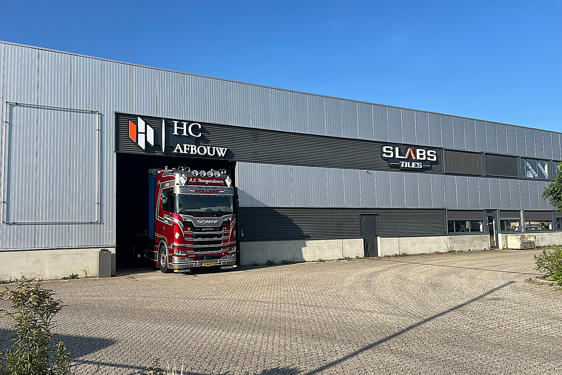 Zijaanzicht van het pand van HC Afbouw met de showroom van SLABS Tiles